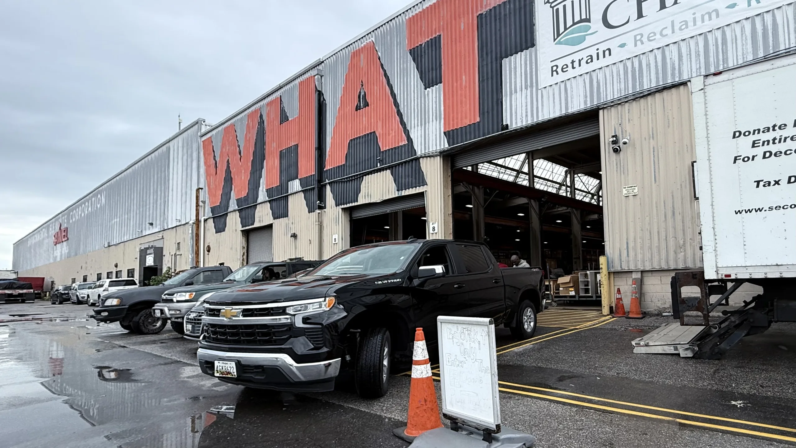 Exterior of the Second Chance, Inc. Baltimore non-profit warehouse, featuring loading bays and trucks, where salvaged and secondhand building materials, vintage furniture, and antique hardware are processed.