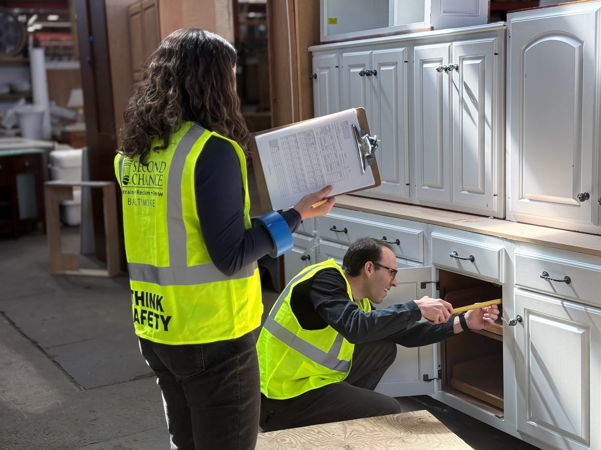 Two volunteers measure kitchen cabinets at our 400,000-square-foot retail footprint in South Baltimore, MD.