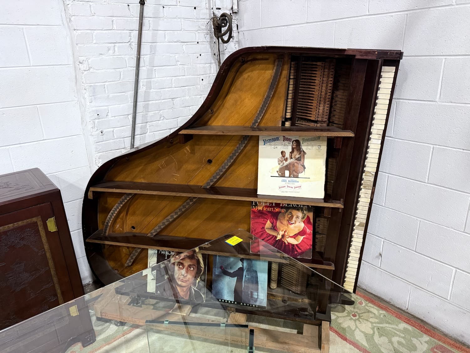 A reclaimed piano transformed into a vinyl record display shelf, an example of reuse from the warehouse at Second Chance, Inc. in South Baltimore, Maryland.